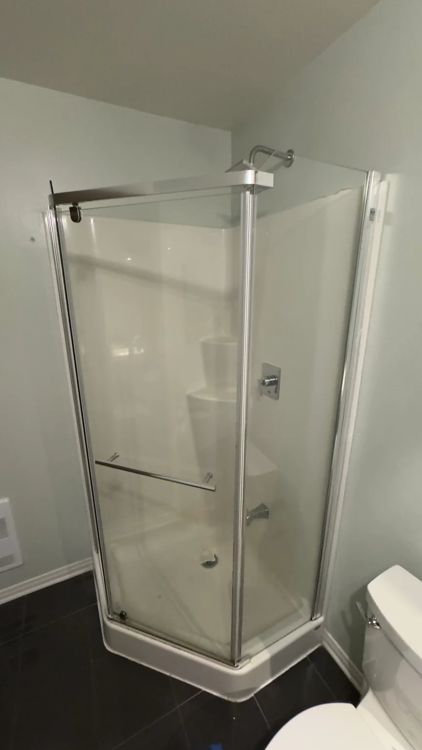Close view of the original prefabricated corner shower before demolition.