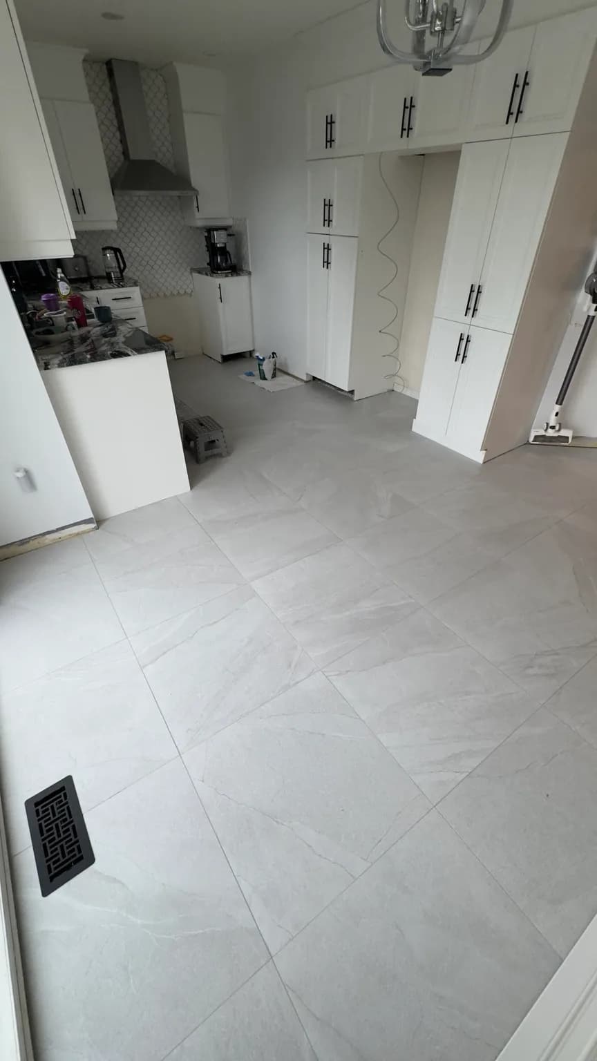 Plancher de porcelaine 24 × 24 terminé dans une cuisine résidentielle à Laval-des-Rapides.